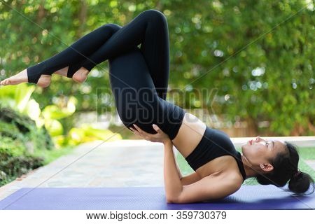 Asian Woman Practice Yoga In A Garden