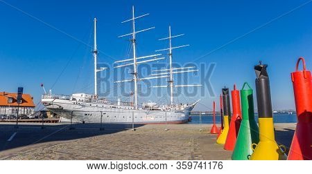 Stralsund, Germany - April 18, 2019: Panorama Of Colorful Buoys In Front Of The Gorch Fock Ship In S