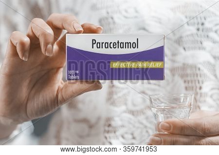 Woman Hold A Box Of 1000mg Paracetamol Tablet In Her Hand And A Glass Of Water