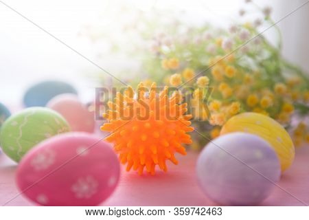 Virus Model Of Coronavirus Disease Covid-19 With Colorful Easter Eggs On A Pink Wooden Table Backgro