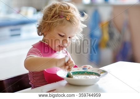 Adorable Baby Girl Eating From Spoon Vegetable Noodle Soup. Food, Child, Feeding And Development Con