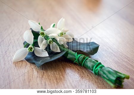 Close-up Of A Snowbell Bouquet On A Wooden Table. Copy Space.