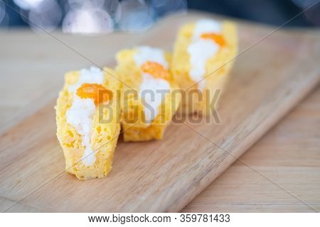 Grilled Tamago Sushi With Rice And Ebiko On Wood Tray
