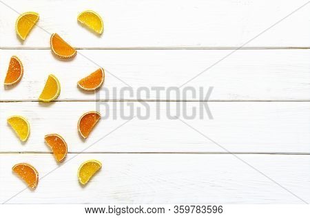 Multicolored Fruit Marmalade Rests On A White Wooden Background
