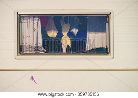 Holidays, Dventure Concept. Clothes Hanging To Dry Indoors In Camper Car Window. Viev From Outside.