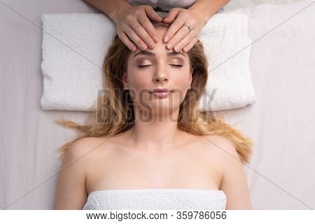 Healing Touch Of An Alternative Medicine Practicioner Touching With Fingers A Forehead Of An Attract