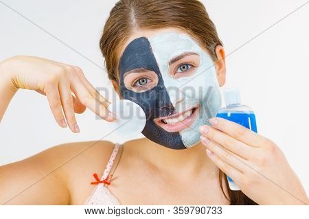 Woman With Clay Carbo Black Mask On One Half Face And White Mud On Second Half. Girl Removing Cosmet