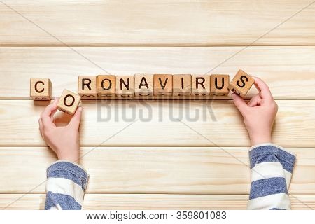 Child Stays At Home Due To Covid-19 Impact. Coronavirus Covid-19 Word Made From Wooden Cubes. Sars-c