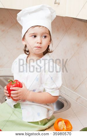 สาวน้อยในห้องครัวจัดการกับพริกไทยบัลแกเรีย