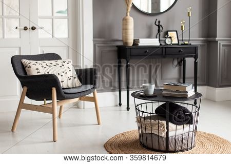 Modern Interior Of A Living Room With Stucco Molding On The Walls, An Armchair, A Mirror And A Conso