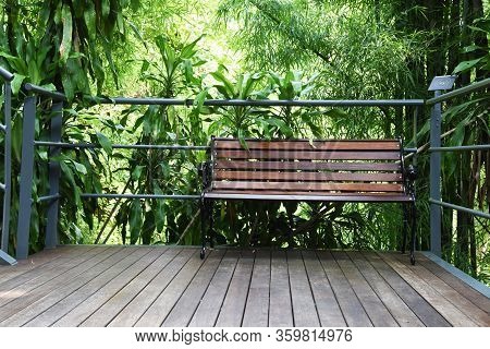 Metal Garden Chair With Brown Wood In The Green Garden