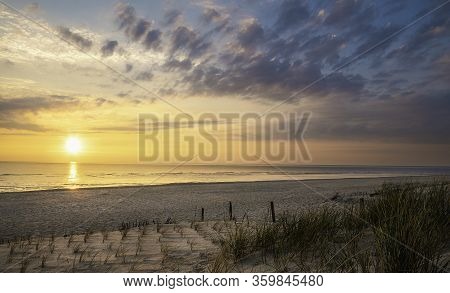 Beach Landscape With Marram Grass And The Sun Setting Over The North Sea, On Sylt Island, Germany. S