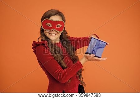 Winter Carnival. Secret Santa Gift Concept. Kid Wear Eye Mask. Girl In Mask Orange Background. Winte