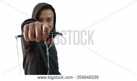 A Northeast Indian Asian Man In A Hoodie And Headphone Plugged In Mobile Showing Fist At The Camera 