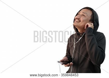 A Japanese Man In Hoodie Listening To Music With Headphones From Mobile And Looking At A Blank Copy 