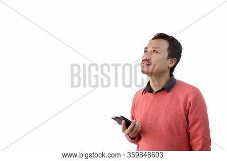 A Man With A Mobile Phone In Hand Isolated In White Background Looking At A Blank Copy Space