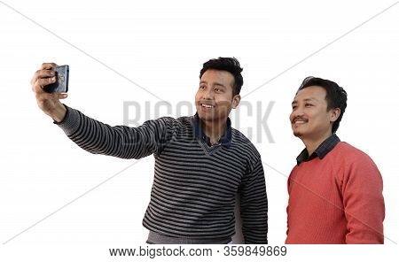 Two Men With Different Ethnicity Taking Selfie Photograph In A Mobile Phone Isolated In White Backgr