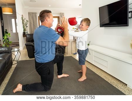 Covid-19 Shutdown. Father And Son Having Fun Boxing Together And Staying Physically Active At Home D