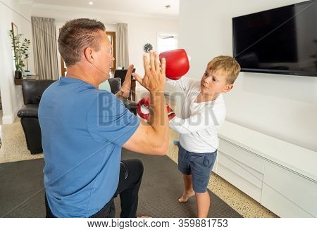 Covid-19 Shutdown. Father And Son Having Fun Boxing Together And Staying Physically Active At Home D
