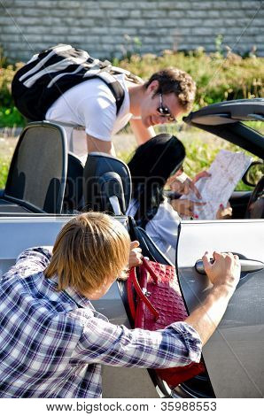 Masculino ladrão roubar a mala do carro, enquanto seu cúmplice distrai motorista feminina