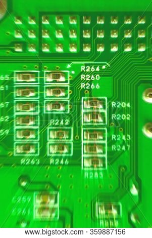 zoom effect closeup yellow-green micro circuit resistors of a computer motherboard