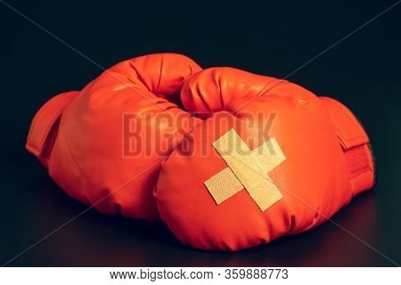 Red Boxing Gloves In The Dark Background. Adhesive Plaster Across Each Other On Boxing Gloves. The I