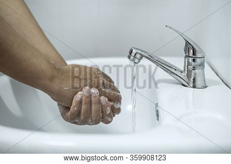 Woman Washing Hands Under The Water Tap In Bathroom With Using Soap Gel For Cleaning And Prevention 