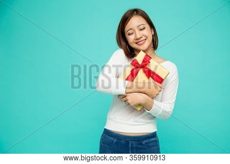 Happy Beautiful Asian Woman Smile With Gold Gift Box Isolated On Green Background. Teenage Girls In 