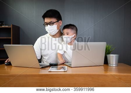 Asian Man It Support Working On Computer Laptop To Remote Desktop With His Son And Wearing Protectiv