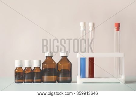 Bottles Of Medicine Lined Up In A Row. Beakers With Chemicals. Chemical Experiments, Vaccines, Blood