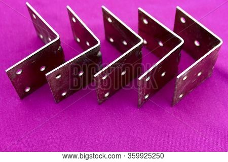 Arrow Made Of Brackets Isolated On Pink. Metal Corners Are Directed To The Right With A Place For Th