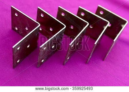 Arrow Made Of Brackets Isolated On Pink. Metal Corners Are Directed To The Right With A Place For Th