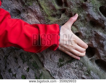 Arm In Red Jacket On The Weathered Sandstone Rock.