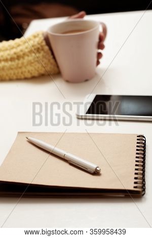 Work At Home. The Entry In The Notebook. Cup Of Coffee In Hand