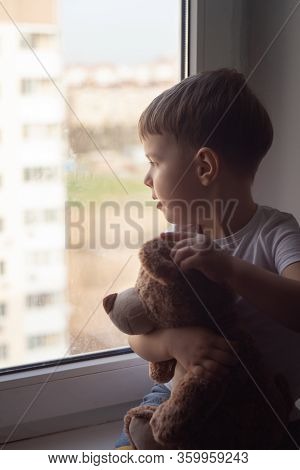Stay At Home Quarantine Coronavirus Prevention Of The Pandemic. A Child And His Teddy Bear On The Wi