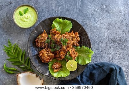 Indian Cuisine. Pakora Traditional Indian Deep-fried Snack. Pakoras On Black Plate With Coconut Chut