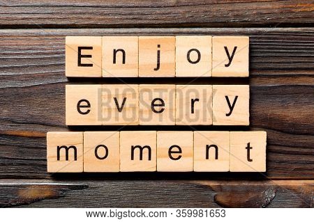 Enjoy Every Moment Word Written On Wood Block. Enjoy Every Moment Text On Wooden Table For Your Desi
