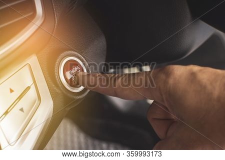 Hand Of Car Driver Press To The Engine Start/stop Button For Engine Ignition In A Luxury Car.