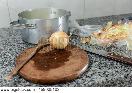 Preparing Items For Cooking An Onion Tart As A Wooden Spoon, A Knife And An Onion. There Is A Pan Fu