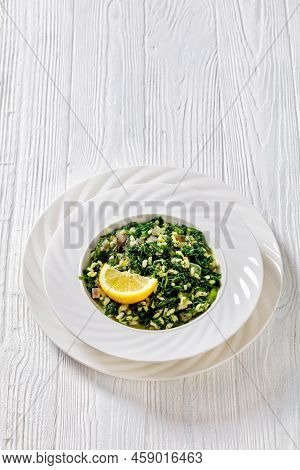 Spanakorizo, Greek Spinach And Rice Pilaf With Lemon, Dill, Spring Onion In White Bowl On White Wood