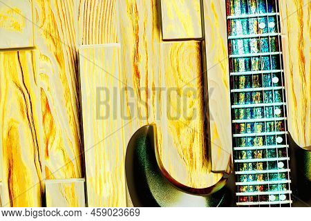 Glam Indie Rock Funky Electric Guitar In Neon Yellow Light On A Wooden Surface