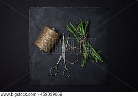 String Beans On A Black Background. A Bunch Of Raw Green Beans Tied With A Rope. Healthy Vegetable