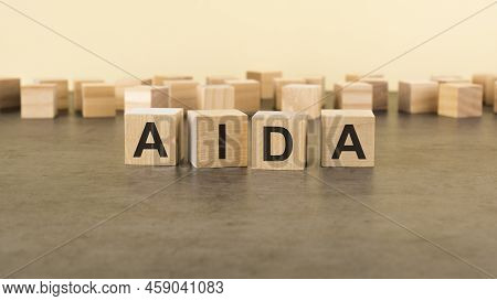 Four Wooden Blocks With The Letters Aida - On The Surface Table. Aida - Attention Interest Desire Ac
