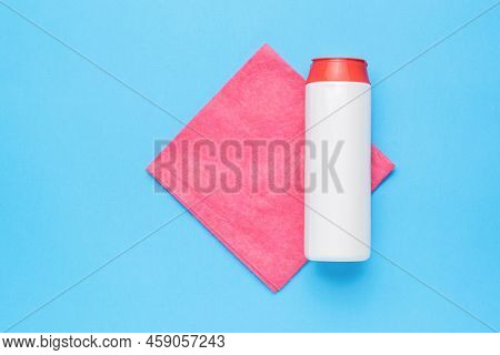 A White Jar With Cleaning Agent And A Red Cleaning Cloth On A Blue Background. Cleaning Kit. Flat La