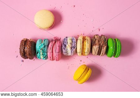 Bright Colorful Various Flavor Macarons Sweet Cookies On Pink Background. Top View