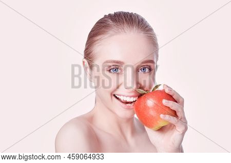 Portrait Of Happy Smiling Young Beautiful Woman Eating Red Apple, Over White Background