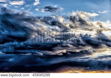Heavily Overcast Autumn Evening Sky With Dark And Sidelit Clouds At Sunset
