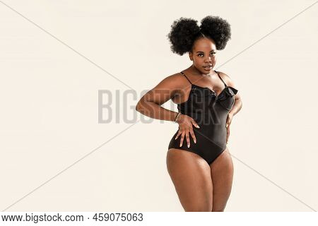 Portrait Of Beautiful Dark Skinned Woman Posing On Light Gray Studio Background, Wearing Black Fashi