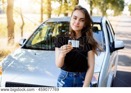 Attractive Caucasian Girl Driver Showing Her Driving License, Happy To Finish Driving School And Pas