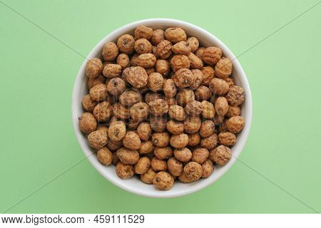 Chufa, Tigernut, Earth Almond On Ceramic Bowl On Green Background. Healthy Organic Food Concept. Tig
